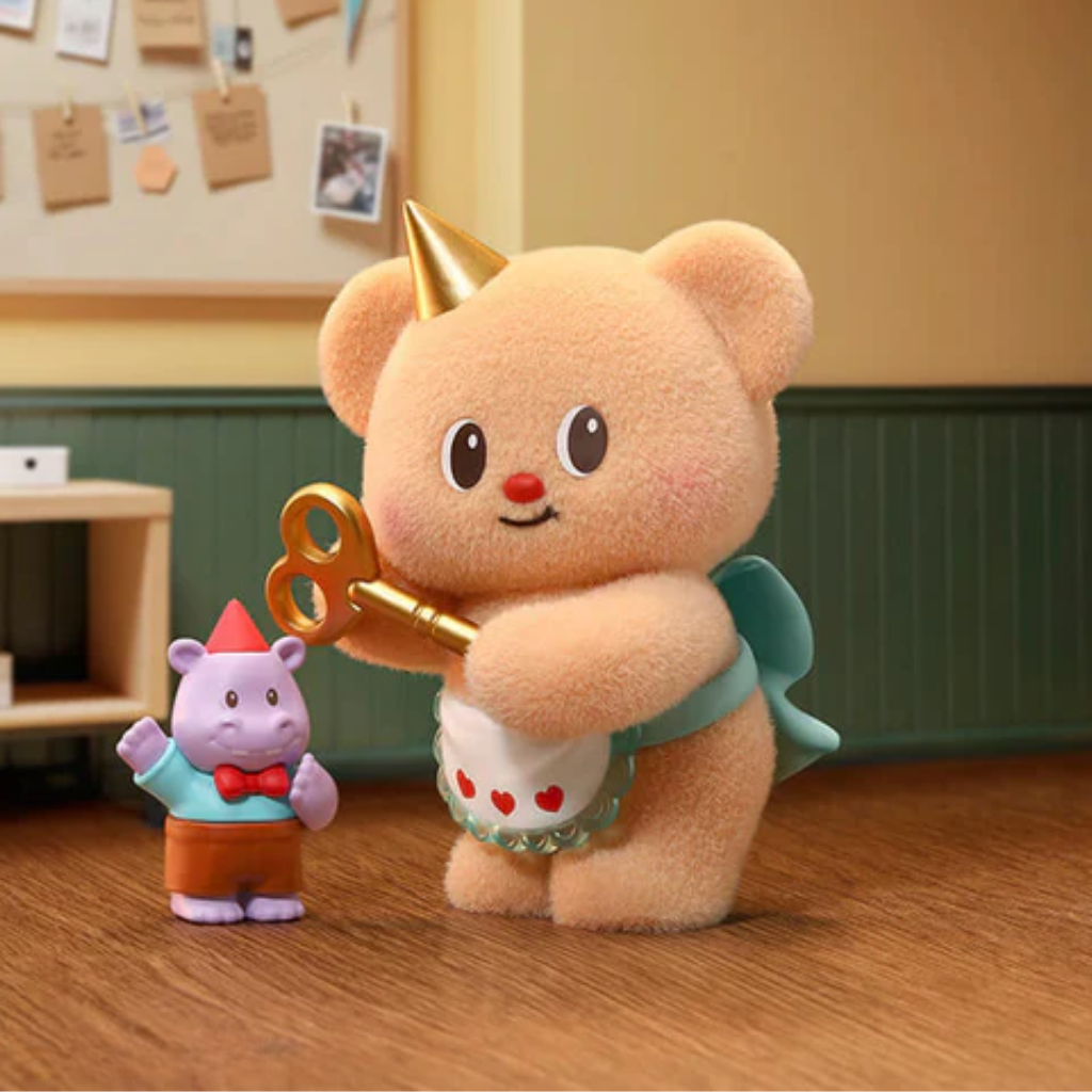 Plush toy bear with a key and small plush hippo in a classroom setting