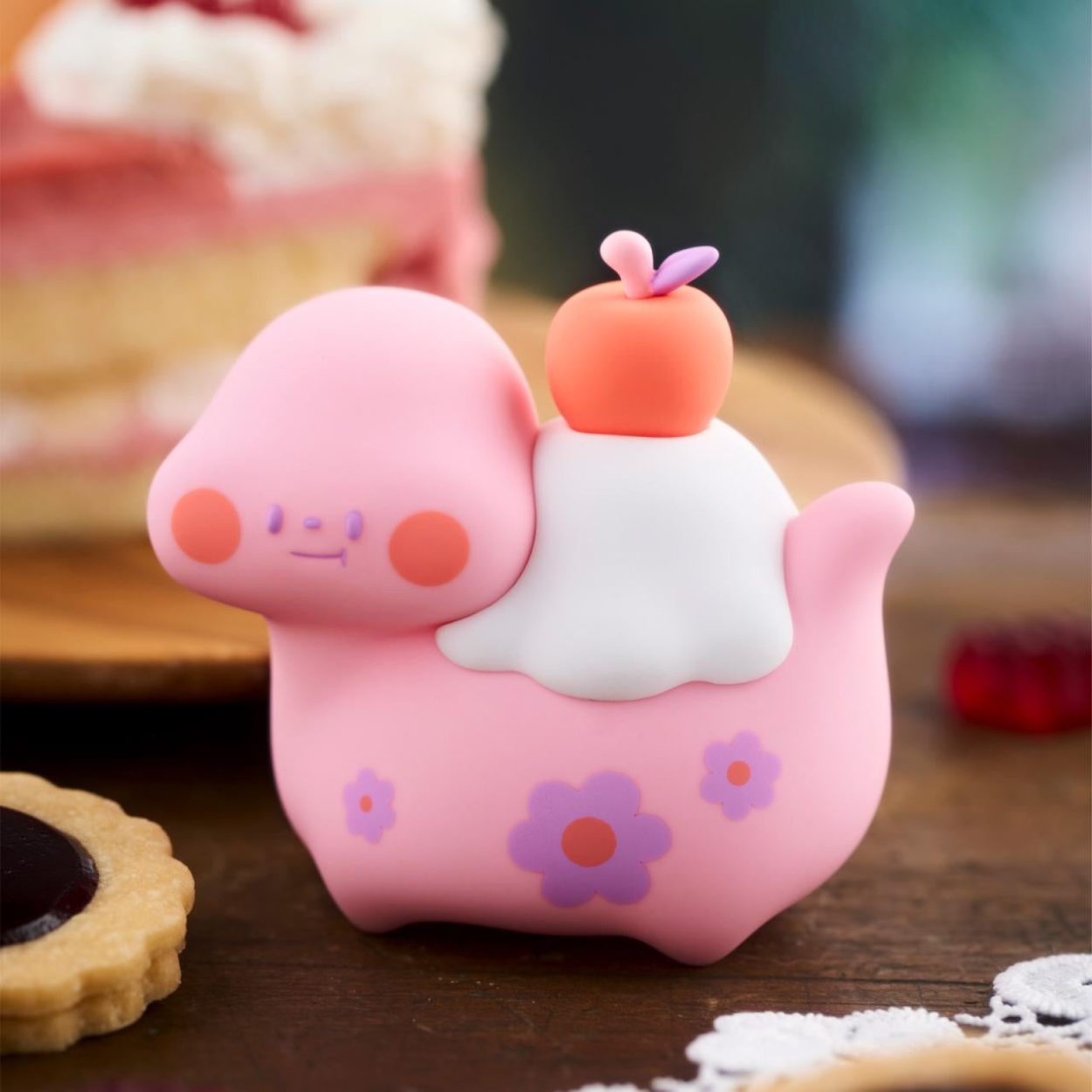 Cute pink cartoon character with a white cloud on a wooden surface
