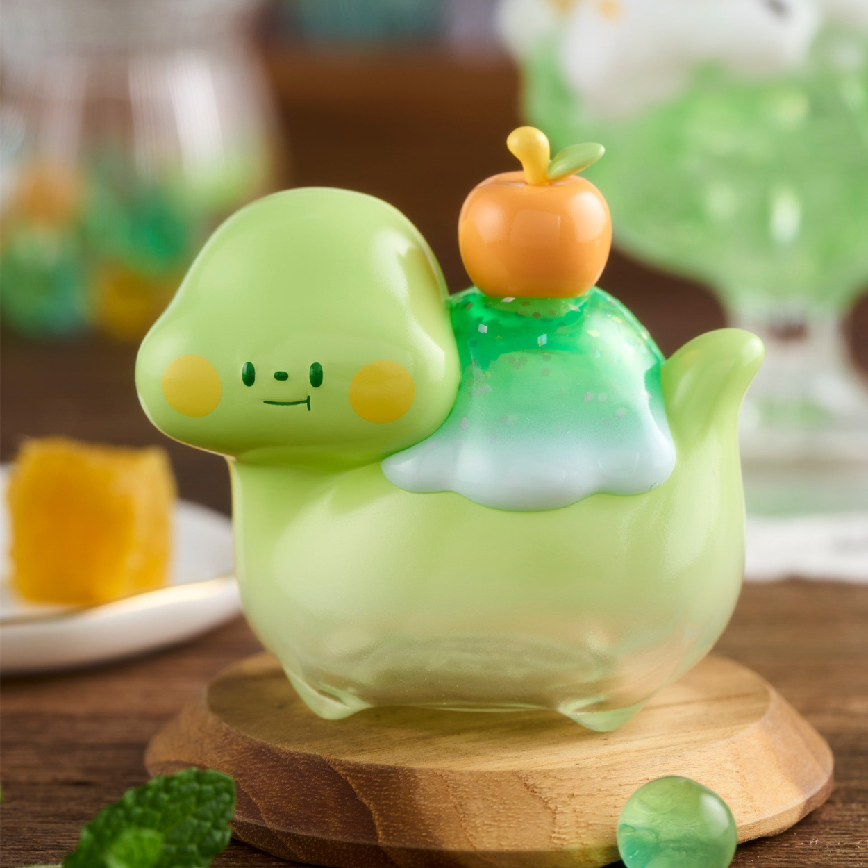 Green dinosaur-shaped container with a small pumpkin on a wooden base