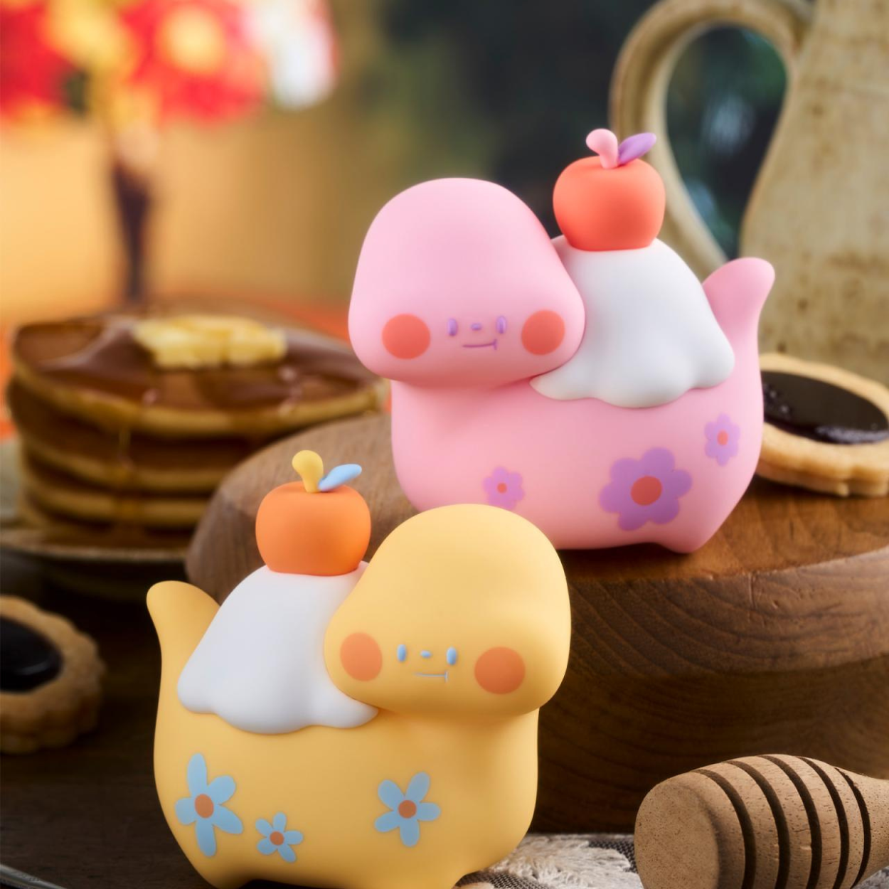 Two colorful cartoon-style characters on a wooden surface with a blurred background
