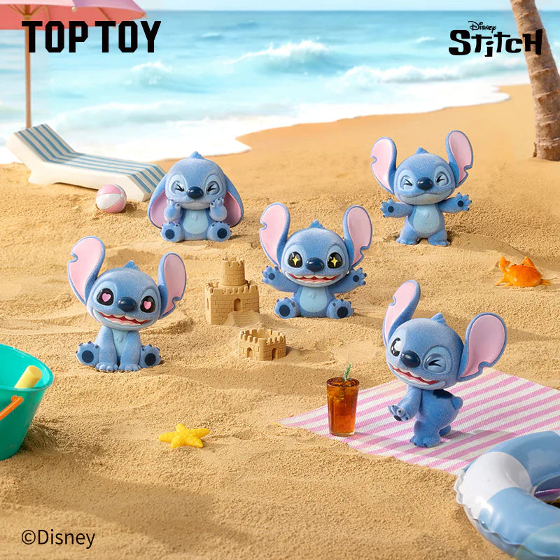 Stitch toy figures on a sandy beach with a palm tree and umbrella in the background.