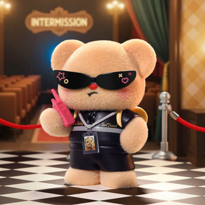 Teddy bear with sunglasses and a pink gun in a theater setting