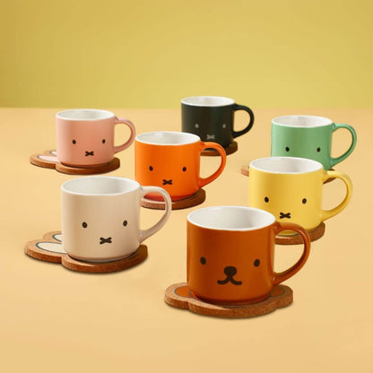 Set of colorful mugs with facial expressions on a yellow background